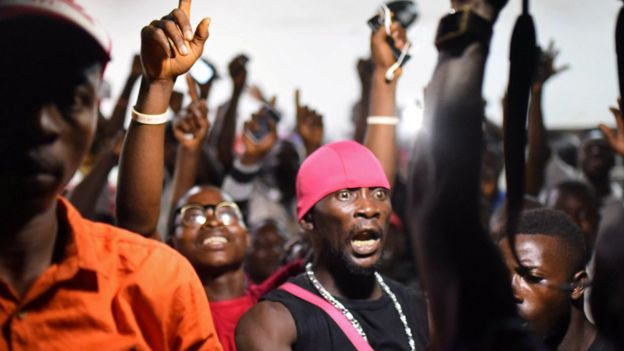 People gesture as they show their support for the ruling All Peoples Congress (APC) party outside the party"s headquarters in Freetown, Sierra Leone March 13, 2018