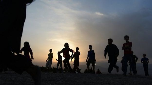 Afghan children run to see the largest Afghan flag after an inauguration ceremony at Wazir Akbar Khan hill in Kabul on September 10, 2014.