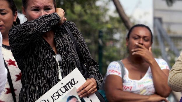 Una mujer familiar de un desaparecido de Jalisco se tapa la nariz con el brazo.