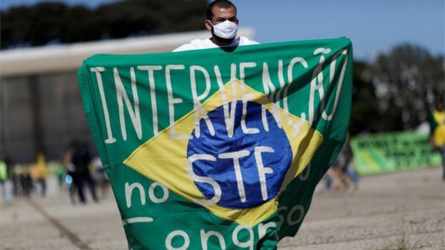 Homem segura faixa pedindo intervenção no STF