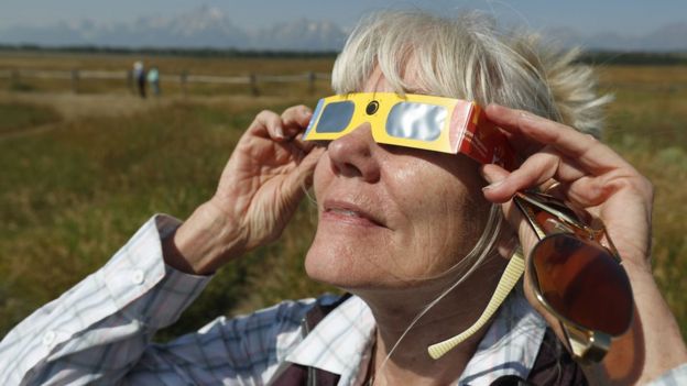 Penny Farster-Narlesky, de Denver, Colorado, prueba sus gafas para ver el eclipse junto al centro de información del Parque Nacional de Grand Teton, Wyoming, Estados Unidos, el 20 de agosto de 2017.