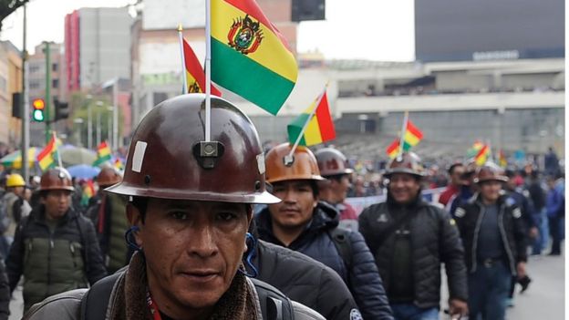 hombre boliviano con casco y bandera