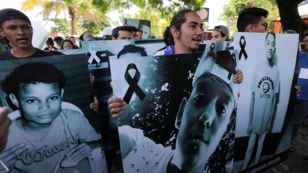 Manifestantes con fotos de los muertos