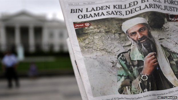 A man takes pictures of the front page of a newspaper featuring a picture of Al-Qaeda leader Osama bin Laden, in front of the White House in Washington, DC, 2 May 2011.