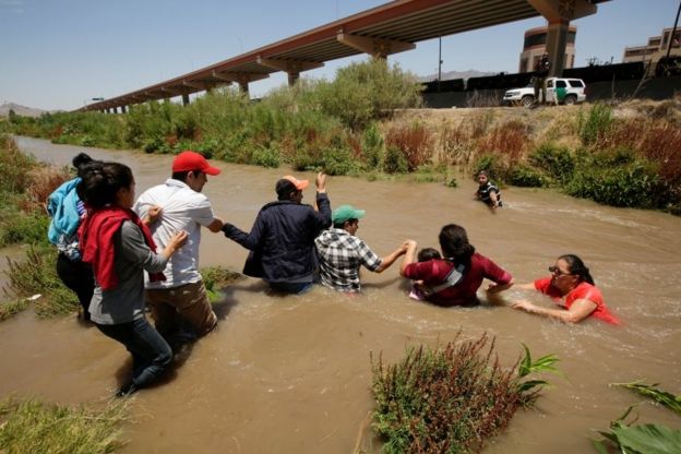 Migrantes cruzando un rÃ­o fronterizo