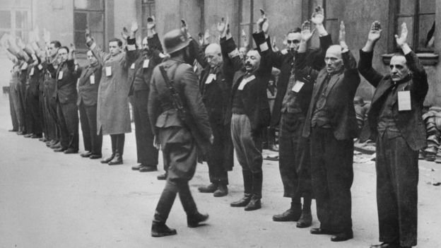 Soldado da SS inspeciona judeus no gueto de Varsóvia, na Polônia, em 1943