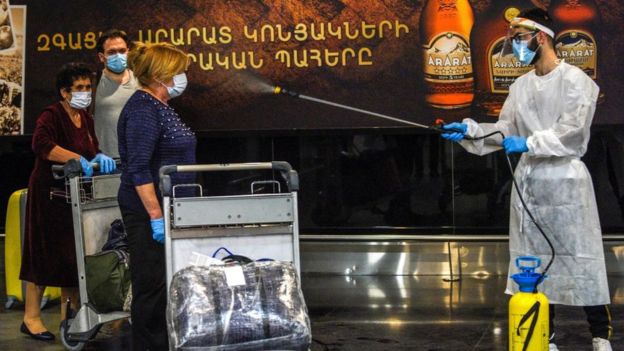 Health workers spray airport arrivals in Yerevan, Armenia