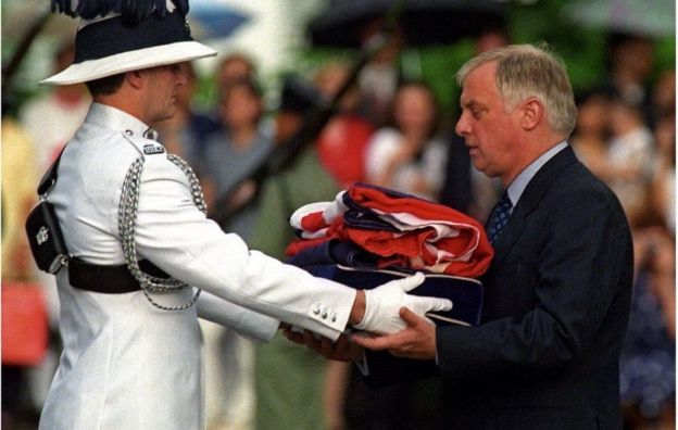 El último gobernador de Hong Kong, Chris Patten, recibe la bandera británica