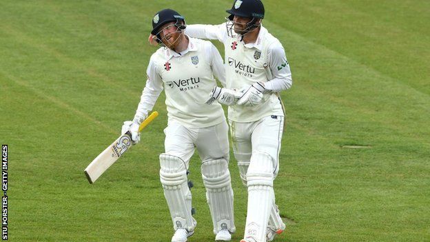 Jack Burnham was congratulated by Stuart Poynter (right) after making his first century for Durham in five years