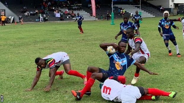 Cameroon players (in blue) in action against Ghana