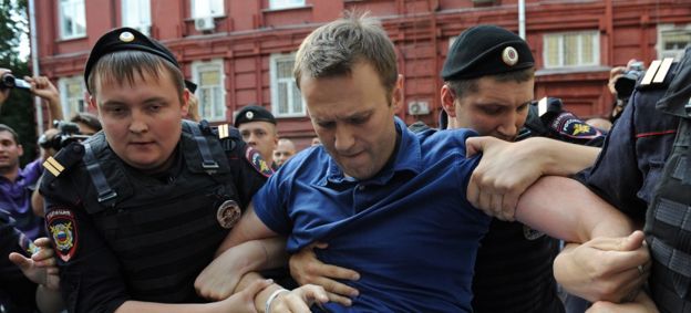 Police officers detain Russia's top opposition figure Alexei Navalny (C) after his visit the city's election commission office to submit documents to get registered as a mayoral election candidate in Moscow July 10, 2013.