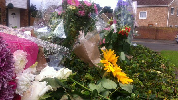 Floral tributes outside the scene of a suspected murder in St Neots
