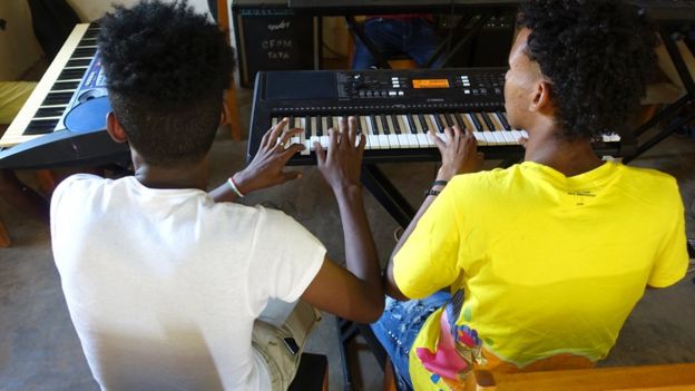 Two people playing the electric piano