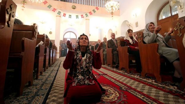 Una mujer reza en una iglesia católica en Irak.