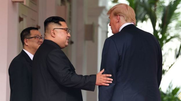 North Korea's leader Kim Jong Un (C) gestures as he meets with US President Donald Trump (R)