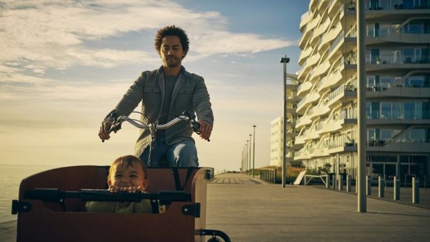 Pai dinamarquês levando o filho para um passeio de bicicleta