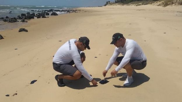 Dois homens da Marinha fazem análise de mancha de óleo na areia de praia no Rio Grande do Note