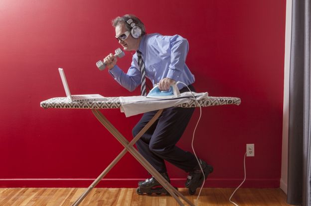 Humorous image of a man ironing, listening and roller skating, all at the same time