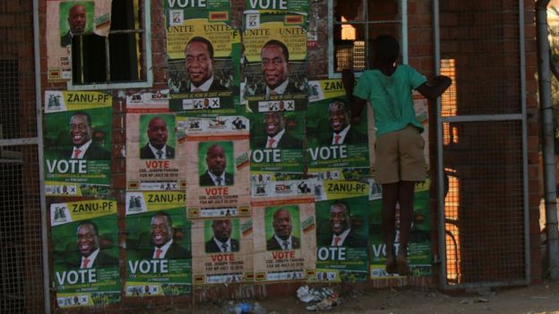 A boy plays next to election posters at White City Stadium where Zimbabwe's President Emmerson Mnangagwa escaped unhurt after an explosion rocked the stadium, in Bulawayo, Zimbabwe, June 23, 2018.