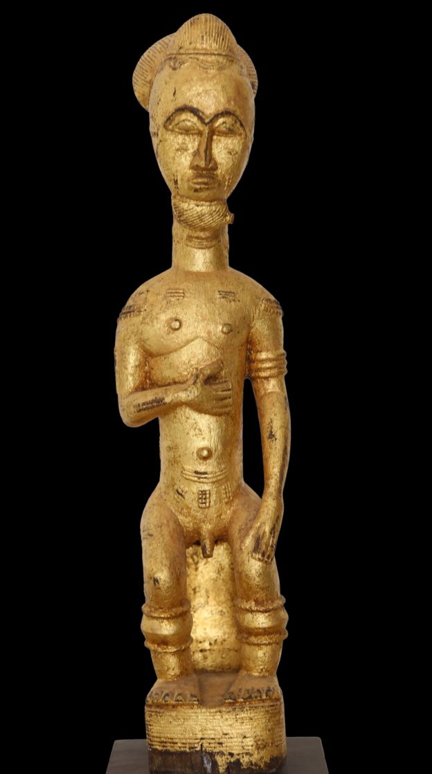 Une statue dorée représentant une figure masculine