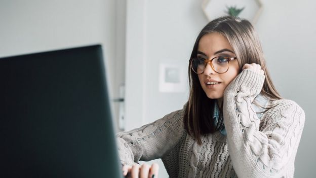 Mujer frente a un computador.