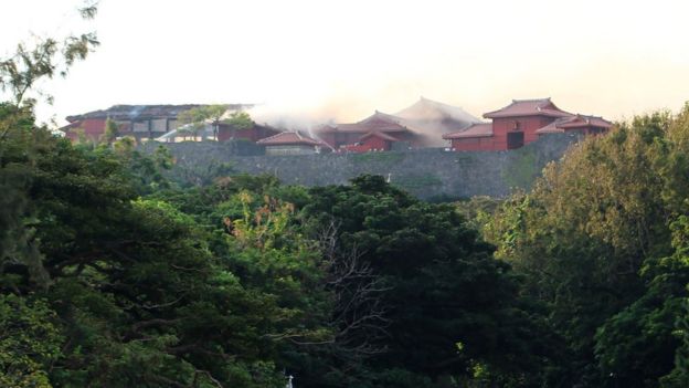Firefighters spray water on the Shuri Castle in Naha