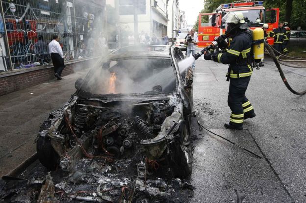 A firefighter works at the scene where a number of cars burnt down during the G20 summit in Hamburg, Germany, 7 July