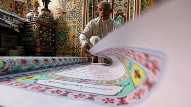 سعد محمد يقلب صفحات نسخة أخرى من المصحف كتبها بخط يده