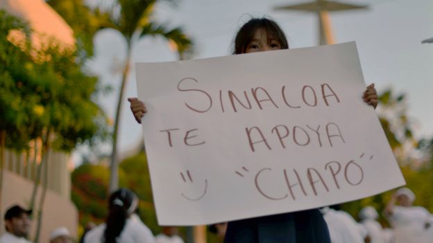 Una niña con un cartel de apoyo al Chapo