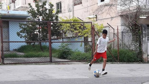 Javier, de 12 años, pateando un balón.