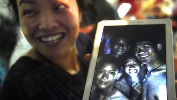 Mulher segura tablet com imagem de meninos vivos no interior de caverna na Tailândia levou alegria a tailandeses e ao mundo -