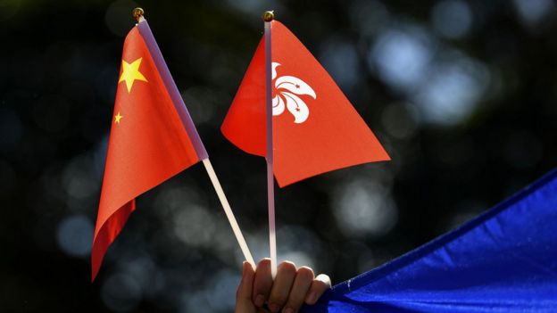 澳大利亚悉尼亲北京示威者与香港“反送中”示威者对峙时举起一对小型中国国旗与香港区旗（17/8/2019）