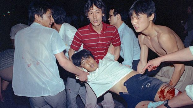 Các sinh viên đưa một người bị thương rời khỏi khu vực bị quân đội đàn áp