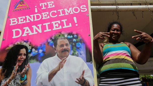 Una mujer junto a un cartel en apoyo a Daniel Ortega