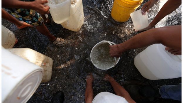 Pessoas coletando água na Venezuela
