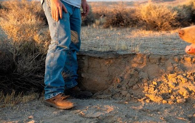 Cư dân địa phương dùng chân để đo mức mặt đất sa mạc bị chuyển do trận động đất mạnh 7,1 độ dọc theo Quốc lộ California 178 giữa Ridgecrest và Trona California, hôm 6/6/2019