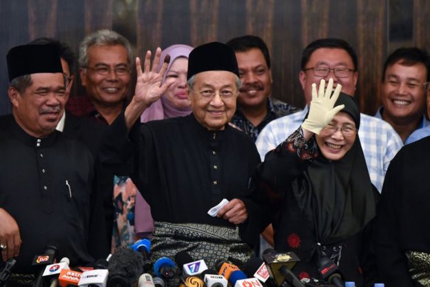 Prime Minister Mahatir Mohamad waves to the crowd at a press conference