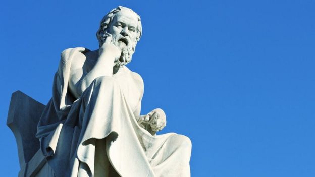 Estatua de Sócrates de mármol blanco con un fondo de cielo azul.