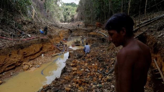 A Yanomami indian follows agents of Brazil's environmental agency in a gold mine during an operation against illegal gold mining on indigenous land, in the heart of the Amazon rainforest, in Roraima state, Brazil April 17, 2016