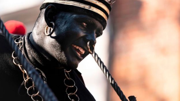 En el festival folclórico belga Ducasse un hombre se pinta la cara de negro para representar al 