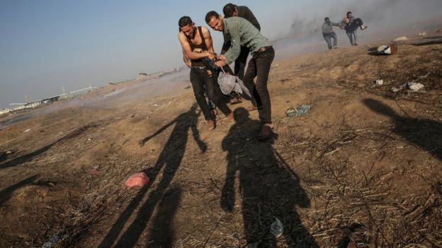 Palestino ferido em Gaza sendo carregado