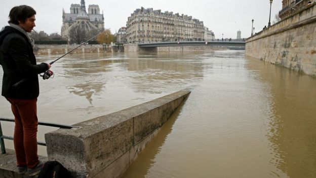 A man fishes on the flooded banks of the River Seine in Paris, France, after days of almost non-stop rain caused flooding in the country, 27 January 2018