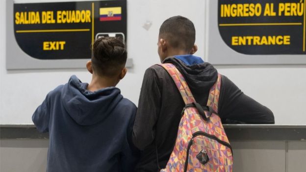 Imagem mostra dois jovens de costas, na fronteira do Equador com o Peru