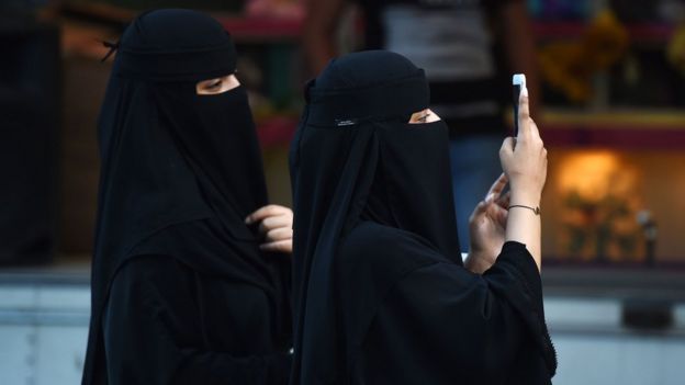 Mulheres sauditas de burca e com celular na mão