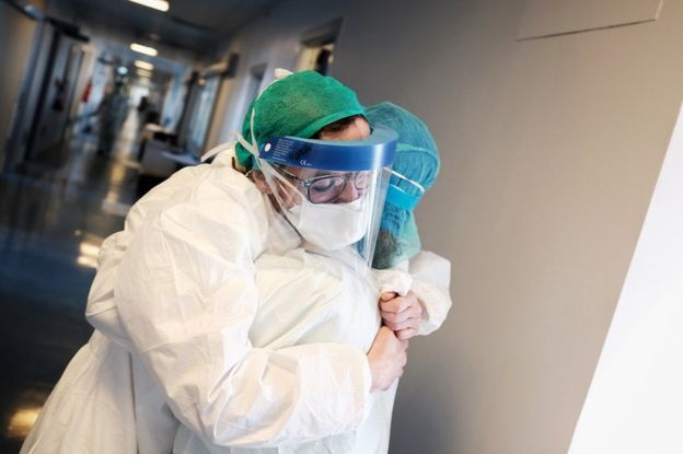 Two hospital members of staff embrace