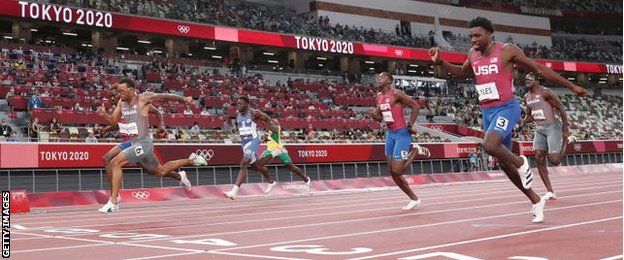 De Grasse (wearing six) and Bednarek (obscured) overhaul Lyles (three) in the final stages of the 200m final