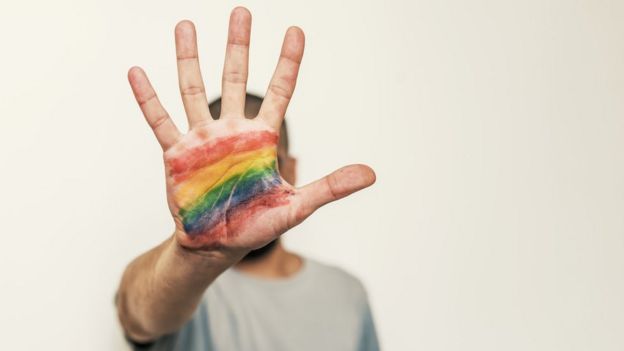 Pessoa com arco-íris na mão