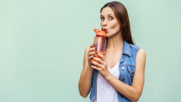 Mujer bebiendo agua.