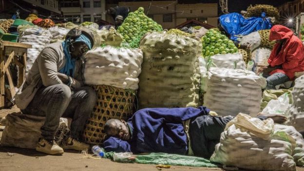 Traders sleep next to items to be sold at a market following a directive from Ugandan President Yoweri Museveni that all vendors should sleep in markets for 14 days to curb the spread of the COVID-19 coronavirus at Nakasero market in Kampala, Uganda, on April 7, 2020