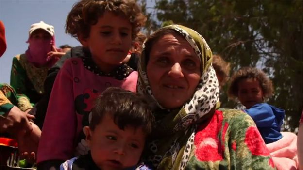 Una mujer junto a unos niños huyen de Raqa.